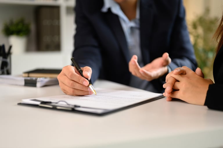 Two business professionals finalizing a vendor deal with documents at modern office desk
