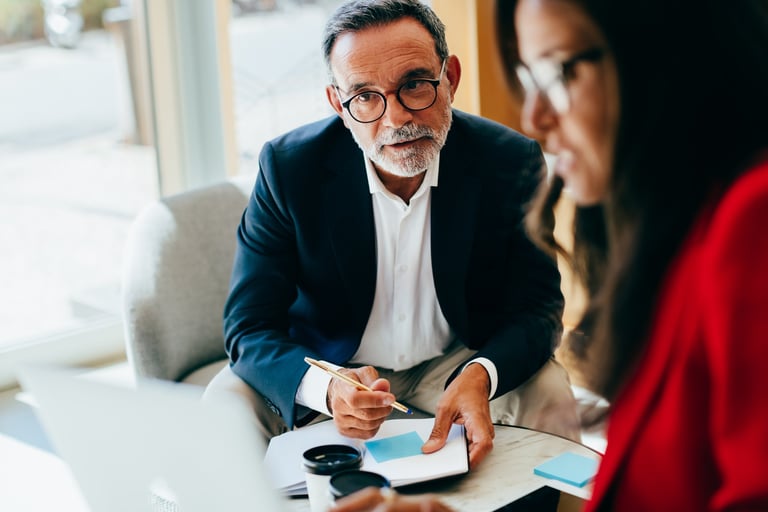 Senior advisor in focused conversation with CEO or CFO during advisory consultation