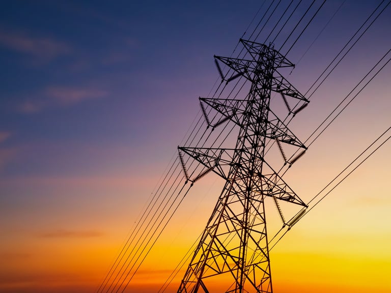 Power line station at night representing energy cost and utility management