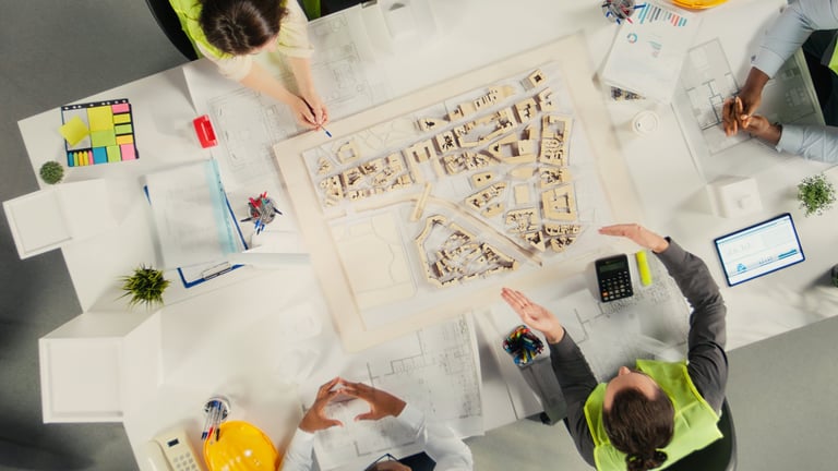 Top down view of architects and engineers collaborating on housing and city planning