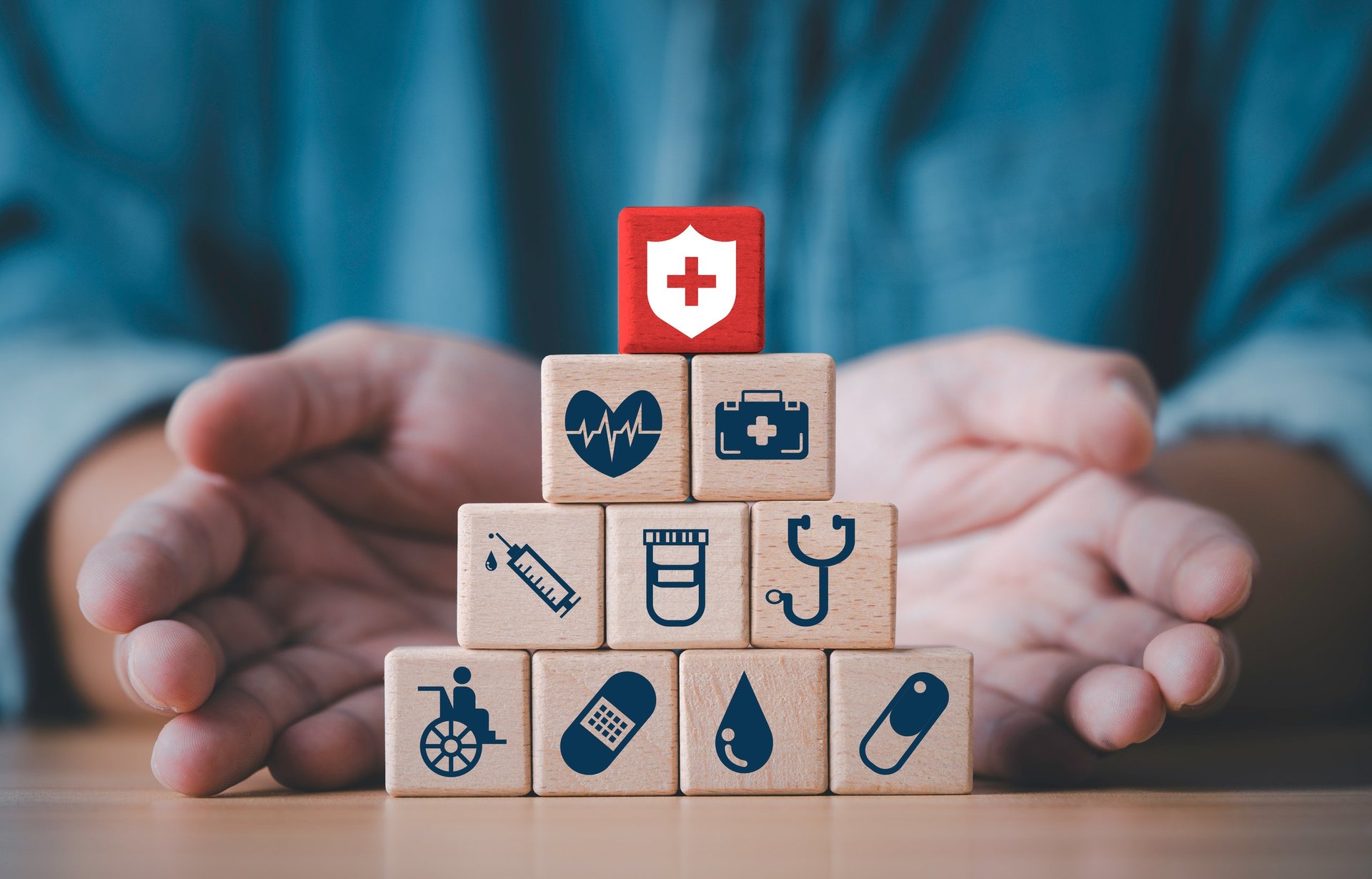 Businessman hand giving and showing a wooden blocks which symbolizing medical protection treatment support and essential healthcare services for patient wellbeing as a health insurance concept