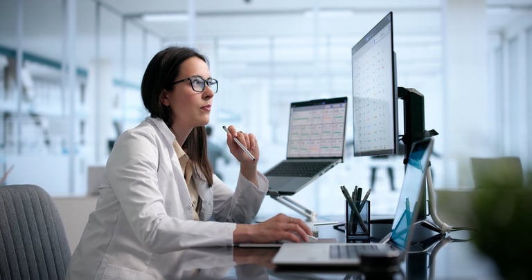 Healthcare Manager Analyzes Patient Data On Laptop For Better Care