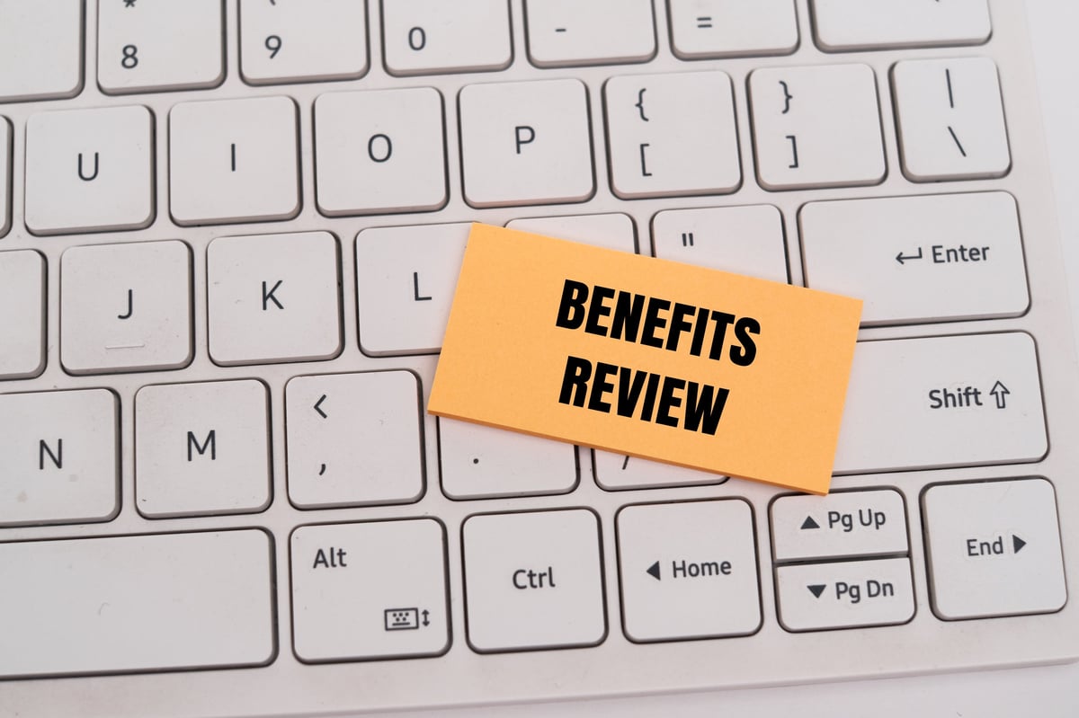 Employer benefits team reviewing a pharmacy benefit manager contract during an annual benefits review for a self-funded health plan